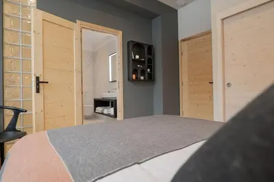 a bedroom with a bed and a door and a bathroom at Appartement Rooftop Chamonix in Chamonix-Mont-Blanc