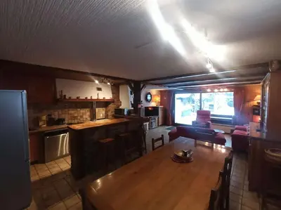 a living room and kitchen with a couch and a table at Belle Vue Des Praz in Chamonix-Mont-Blanc