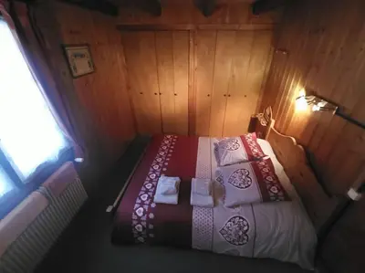 a small bedroom with a bed with pillows at Belle Vue Des Praz in Chamonix-Mont-Blanc