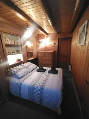 a bedroom with a bed in a wooden room at Belle Vue Des Praz in Chamonix-Mont-Blanc