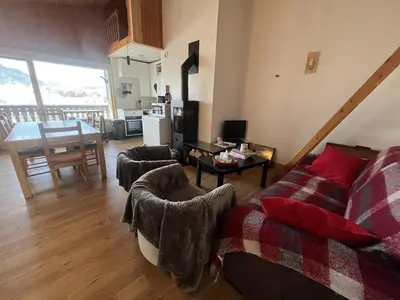 a living room with a couch and a table at Chaleureux 3 pièces + mezzanine, 6/7 pers, poêle à bois, balcon ouest, parking, proche centre et pistes - FR-1-572-271 in Arâches-la-Frasse
