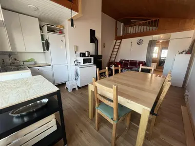 a kitchen and dining room with a wooden table and chairs at Chaleureux 3 pièces + mezzanine, 6/7 pers, poêle à bois, balcon ouest, parking, proche centre et pistes - FR-1-572-271 in Arâches-la-Frasse