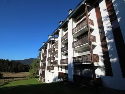 an apartment building with balconies on the side of it at Chaleureux 3 pièces + mezzanine, 6/7 pers, poêle à bois, balcon ouest, parking, proche centre et pistes - FR-1-572-271 in Arâches-la-Frasse