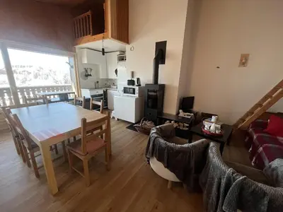 a kitchen and living room with a table and chairs at Chaleureux 3 pièces + mezzanine, 6/7 pers, poêle à bois, balcon ouest, parking, proche centre et pistes - FR-1-572-271 in Arâches-la-Frasse