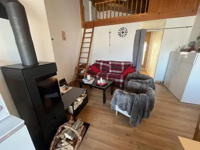 a living room with a wood stove and a couch at Chaleureux 3 pièces + mezzanine, 6/7 pers, poêle à bois, balcon ouest, parking, proche centre et pistes - FR-1-572-271 in Arâches-la-Frasse