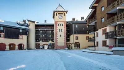 a building with a clock tower in the snow at Grand Morillon-309 Appart vue pistes- 5 pers in Morillon