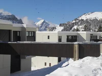a building in the snow with mountains in the background at Studio rénové avec cabine et balcon au centre de Flaine - FR-1-425-196 in Arâches-la-Frasse