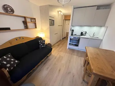a living room with a couch and a table and a kitchen at Studio rénové avec cabine et balcon au centre de Flaine - FR-1-425-196 in Arâches-la-Frasse