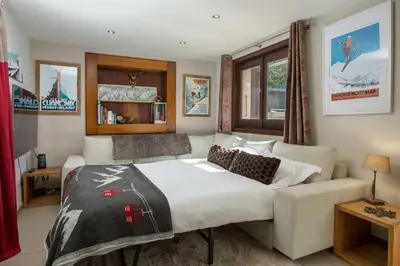 a bedroom with a bed and a couch at Chalet le Tremplin in Chamonix-Mont-Blanc