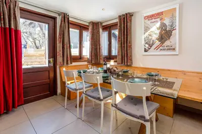 a dining room with a table and chairs and a movie poster at Chalet le Tremplin in Chamonix-Mont-Blanc