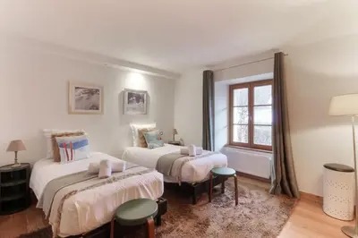 a bedroom with two beds and a window at Les Alpins - Centre de Chamonix - Rénové avec Jardin et vue imprenable sur le MontBlanc in Chamonix-Mont-Blanc