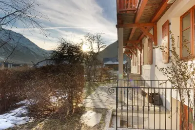 a gate to a house with the sun in the background at Les Alpins - Centre de Chamonix - Rénové avec Jardin et vue imprenable sur le MontBlanc in Chamonix-Mont-Blanc