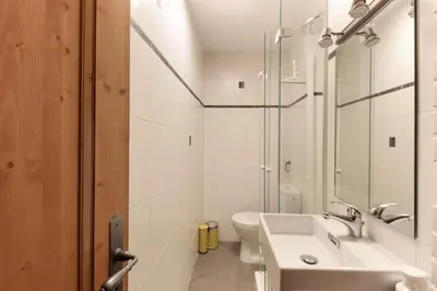 a white bathroom with a sink and a toilet at Les Alpins - Centre de Chamonix - Rénové avec Jardin et vue imprenable sur le MontBlanc in Chamonix-Mont-Blanc