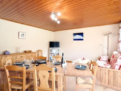 a dining room with a wooden table and chairs at Apartment Le Nerey-2 by Interhome in Saint-Gervais-les-Bains