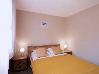 a bedroom with a yellow bed with two night stands at Apartment Le Nerey-2 by Interhome in Saint-Gervais-les-Bains