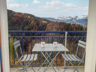 a table and chairs on a balcony with mountains at Apartment Le Domaine de Crespin by Interhome in Saint-Gervais-les-Bains