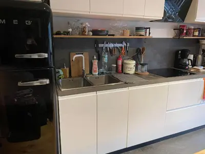 a kitchen with a sink and a black refrigerator at Cozy studio au centre du village & superbe vue in Les Contamines-Montjoie