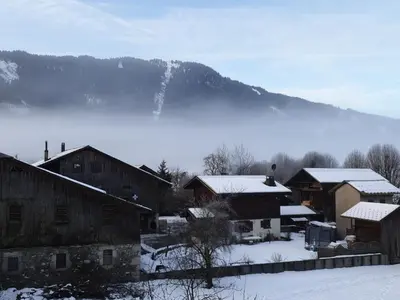 a large building with a mountain in the background at Studio lumineux pour 4 pers, animaux admis, wifi inclus, au centre de Samoëns - FR-1-629-120 in Samoëns