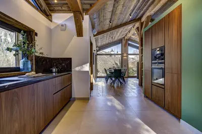 a kitchen with wooden cabinets and a large window at Chalet Green Forest in Chamonix-Mont-Blanc