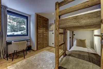 a bedroom with a bed and a desk and a window at Chalet Green Forest in Chamonix-Mont-Blanc