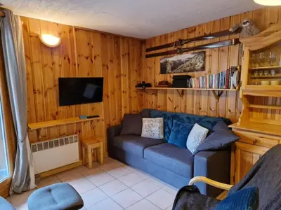 a living room with a blue couch and a tv at Apartment Husky in Saint-Gervais-les-Bains