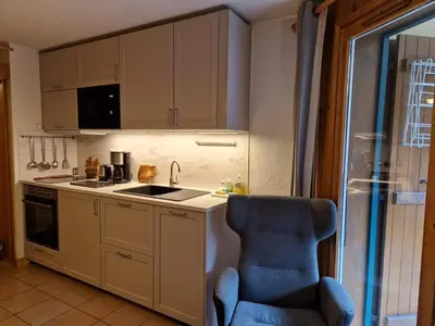 a kitchen with a blue chair and a sink at Apartment Husky in Saint-Gervais-les-Bains