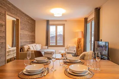 a dining room with a table with plates and wine glasses at Perle Blanche - Brand New 2 bedroom apartment perfectly located in Chamonix-Mont-Blanc