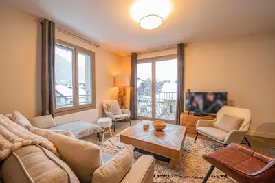 a living room with a couch and a tv at Perle Blanche - Brand New 2 bedroom apartment perfectly located in Chamonix-Mont-Blanc
