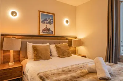 a bedroom with a bed and two lamps and a window at Perle Blanche - Brand New 2 bedroom apartment perfectly located in Chamonix-Mont-Blanc