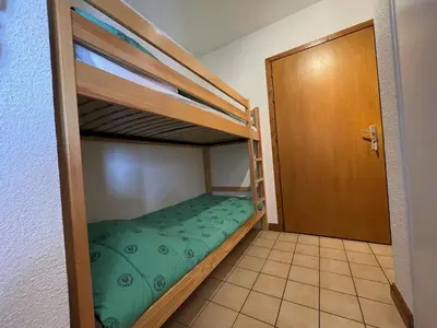 a room with two bunk beds and a door at Studio spacieux 4 pers : parking, lave-vaisselle, proche télécabine - FR-1-572-108 in Arâches-la-Frasse