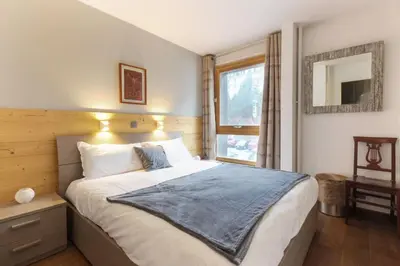 a bedroom with a large bed and a window at L'Outa - Center of Chamonix - Mont-Blanc view in Chamonix-Mont-Blanc