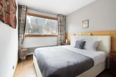 a bedroom with a large bed and a window at L'Outa - Center of Chamonix - Mont-Blanc view in Chamonix-Mont-Blanc