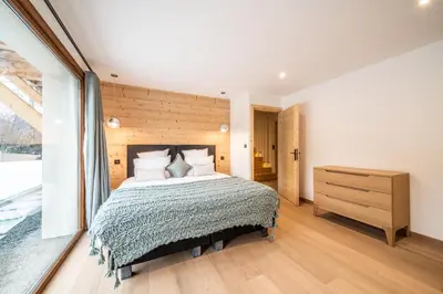 a bedroom with a large bed and a wooden wall at Chalet Arande Saint Gervais - by EMERALD STAY in Saint-Gervais-les-Bains