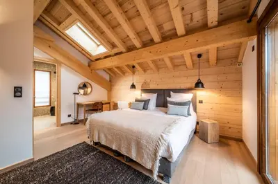 a bedroom with a large bed and wooden ceilings at Chalet Arande Saint Gervais - by EMERALD STAY in Saint-Gervais-les-Bains