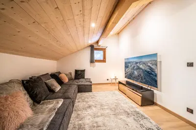 a living room with a couch and a flat screen tv at Chalet Arande Saint Gervais - by EMERALD STAY in Saint-Gervais-les-Bains