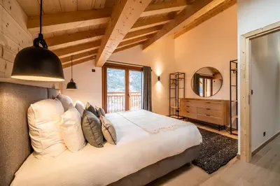 a bedroom with a large bed and a mirror at Chalet Arande Saint Gervais - by EMERALD STAY in Saint-Gervais-les-Bains