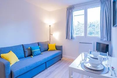 a living room with a blue couch and a table at Forclaz River 1- Beautifully crafted Studio in Chamonix-Mont-Blanc