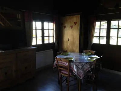 a dining room with a table and chairs and windows at Résidence Mazot De La Princesse - Chalet de la Princesse MAE-0864 in Megève