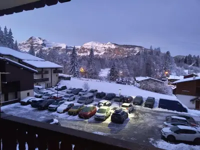 a parking lot covered in snow with cars parked at Appartement Les Carroz d'Araches 4 à 6 couchages, vue sur montagne in Les Carroz d'Araches