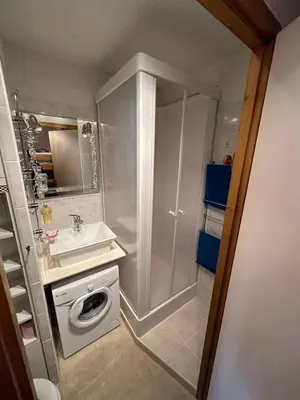 a bathroom with a sink and a washing machine at Appartement Les Carroz d'Araches 4 à 6 couchages, vue sur montagne in Les Carroz d'Araches