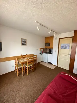 a kitchen and dining room with a table and chairs at Appartement Les Carroz d'Araches 4 à 6 couchages, vue sur montagne in Les Carroz d'Araches