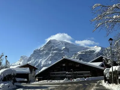 a ski lodge with a snow covered mountain in the background at Appartement Cosy 3 Chambres, Centre-Ville, Proche Pistes, Parking, Wifi - FR-1-572-273 in Arâches-la-Frasse