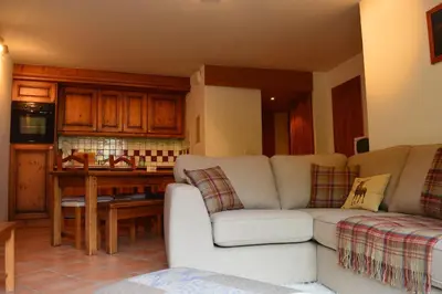 a living room with a couch and a kitchen at 2 bedroom Apartment in Les Houches Stone's throw from Prairon lift in Les Houches