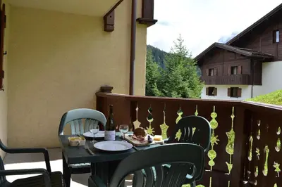 a table with a child sitting on it on a balcony at 2 bedroom Apartment in Les Houches Stone's throw from Prairon lift in Les Houches
