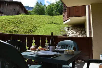 a table with a bottle of wine on a balcony at 2 bedroom Apartment in Les Houches Stone's throw from Prairon lift in Les Houches