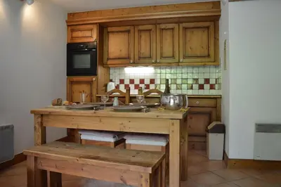 a kitchen with wooden cabinets and a wooden table at 2 bedroom Apartment in Les Houches Stone's throw from Prairon lift in Les Houches