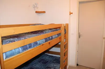 a bedroom with two bunk beds and a door at Les Pierres Blanches Contamines Montjoie in Les Contamines-Montjoie