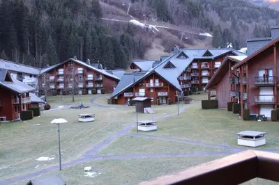 a group of buildings with a grass field in front at Les Pierres Blanches Contamines Montjoie in Les Contamines-Montjoie