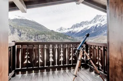 a camera on a balcony with a view of mountains at Chalet Kieppi - View off Mont-Blanc range in Les Houches