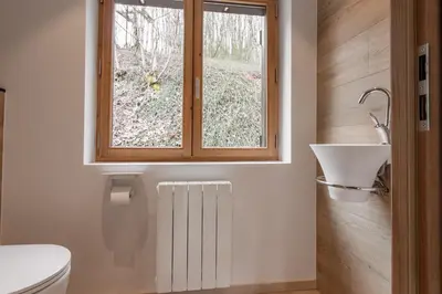a bathroom with a toilet and a sink and a window at Chalet Kieppi - View off Mont-Blanc range in Les Houches